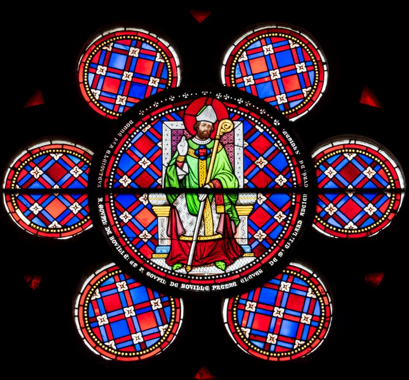 Vitrail représentant un évêque tenant une crosse assis sur un fauteuil entouré de décorations géométriques
