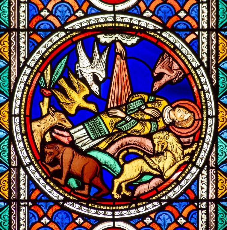 Vitrail représentant un homme mort, saint Etienne, veillé par des animaux sauvages (rapaces, loup, ours, lion)